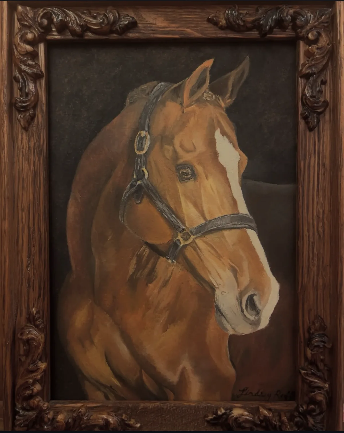 A chestnut horse portrait in a carved wood frame