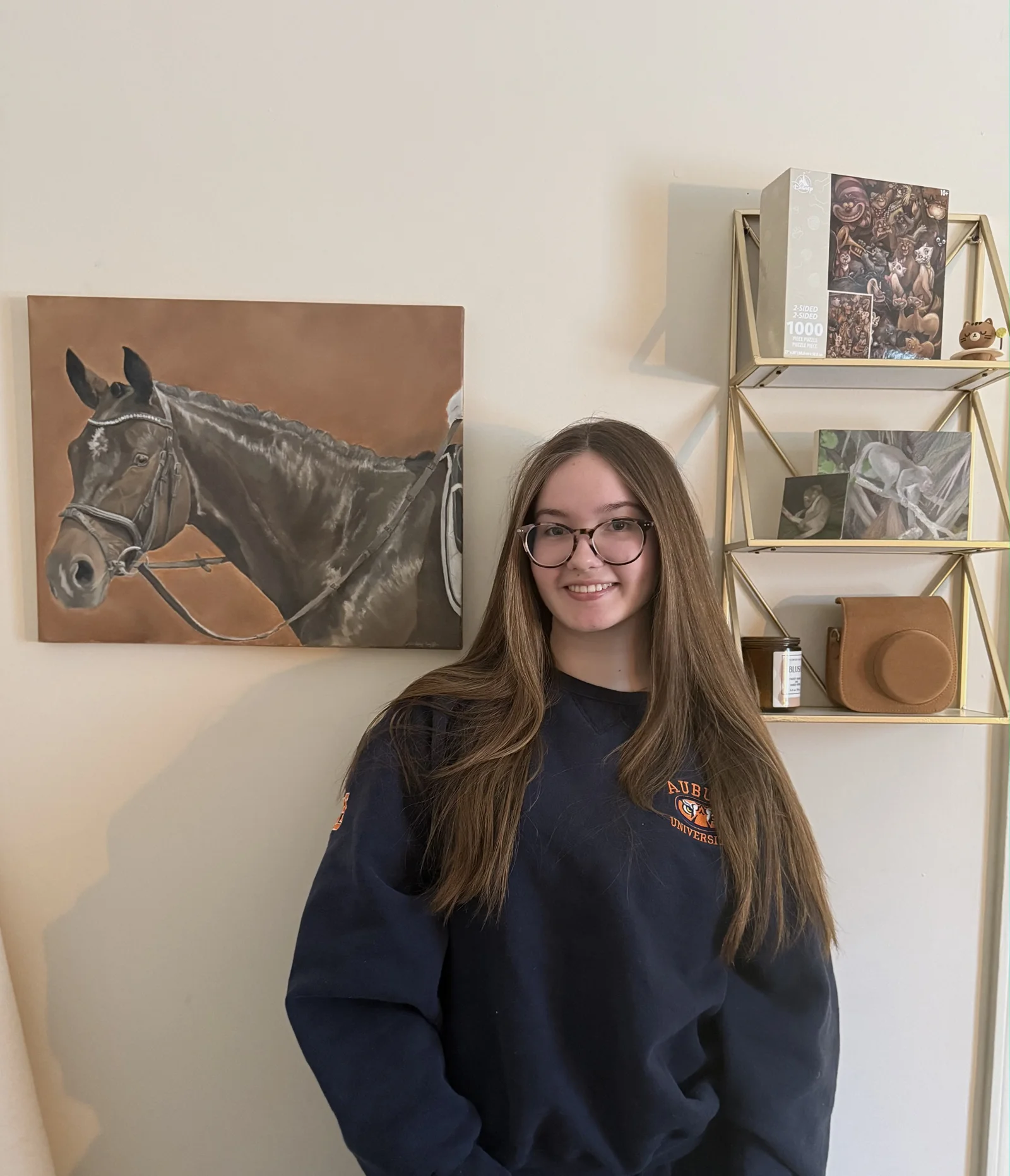 Lindsey Ruffin standing in her studio beside an original horse painting